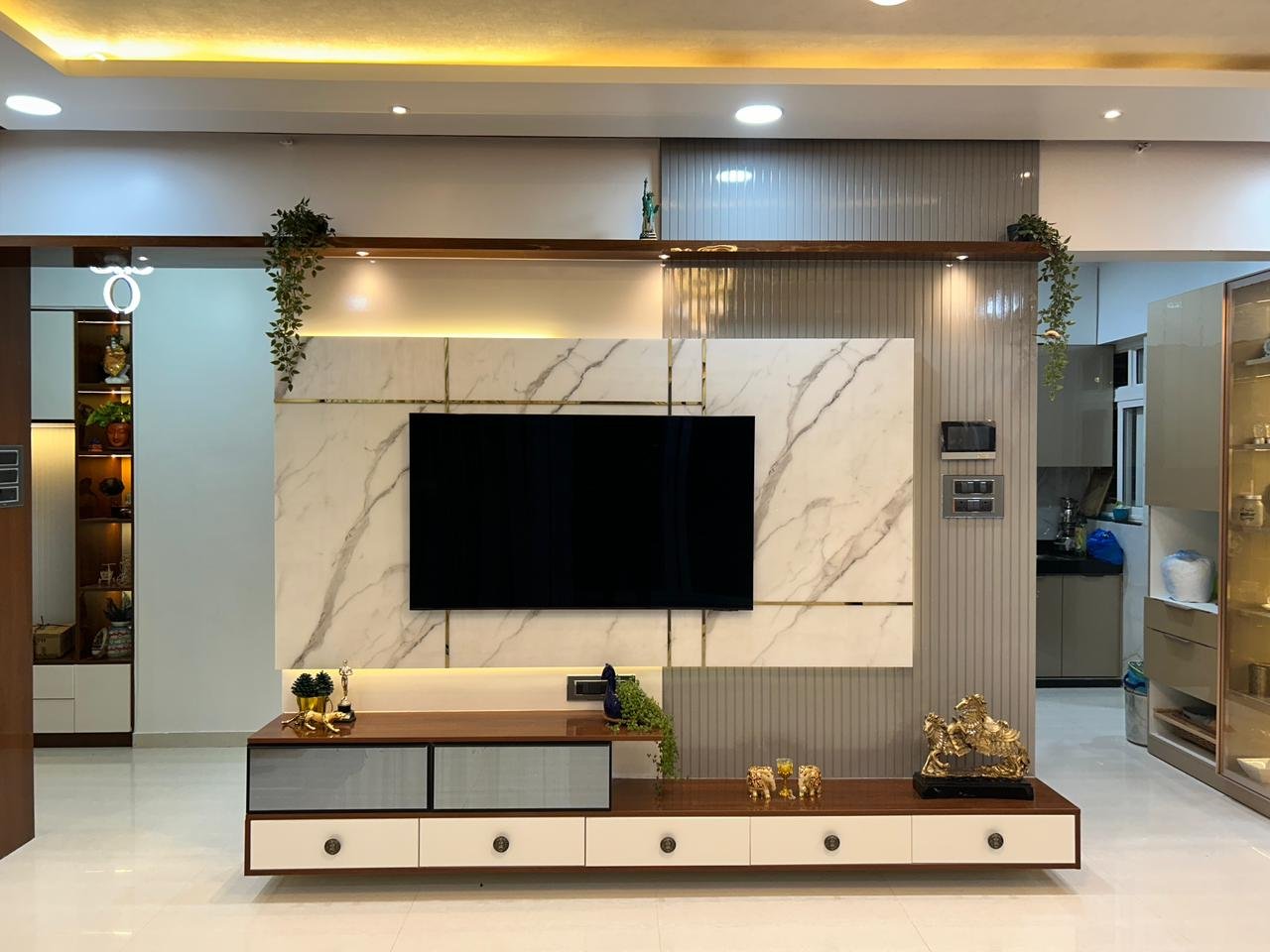 Luxury living room interior with marble television wall by Doric & Co. Pune